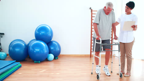 Smiling-physiotherapist-helping-patient-walk-with-zimmer-frame