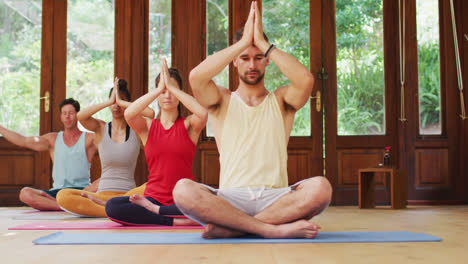 Eine-Vielfältige-Gruppe-übt-Yoga-Positionen-Auf-Matten-Sitzend-Während-Des-Yoga-Kurses-Im-Studio