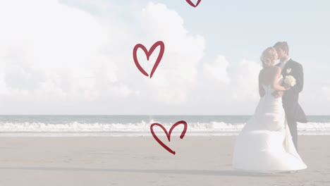 Animation-of-red-hearts-over-caucasian-couple-wearing-wedding-clothes-and-kissing-on-beach