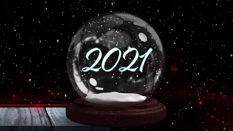 Animation-of-snow-falling-over-snow-globe-with-2021-text-on-black-background