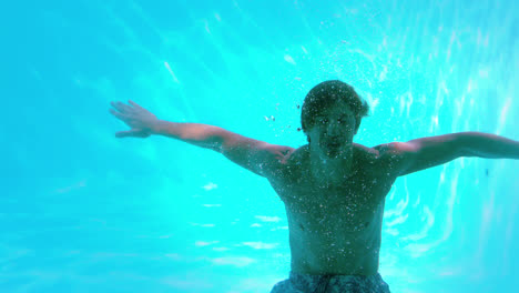 Glücklicher-Mann-Posiert-Unter-Wasser-Im-Schwimmbad