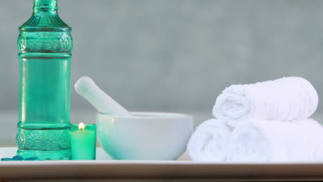 Towels-and-glass-bottle-with-candle-and-mortar-and-pestle