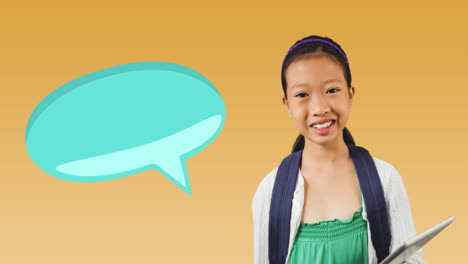 Animation-of-blue-speech-bubble-over-smiling-asian-schoolgirl-holding-book-on-yellow-background