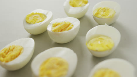 Video-of-close-up-of-halves-of-hard-boiled-eggs-on-grey-background