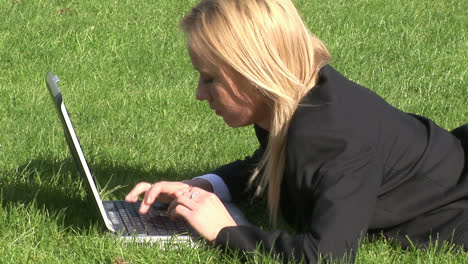 Frau-Liegt-Auf-Dem-Rasen-Mit-Laptop
