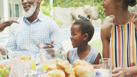 Feliz-Familia-Afroamericana-Hablando-Y-Desayunando-En-El-Jardín