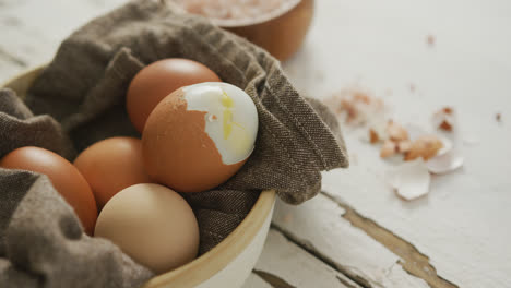 Video-of-close-up-of-hard-boiled-brown-eggs-with-cloth-in-bowl-on-rustic-background