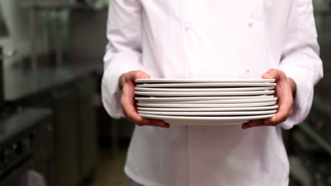 Chef-holding-stack-of-plates