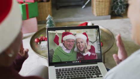 Verschiedene-ältere-Freundinnen-Nutzen-Laptop-Für-Weihnachtsvideoanruf-Mit-Glücklichem-Paar-Auf-Dem-Bildschirm