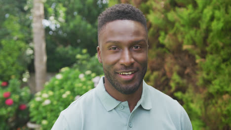Porträt-Eines-Lächelnden-Afroamerikanischen-Mannes,-Der-Im-Garten-In-Die-Kamera-Blickt