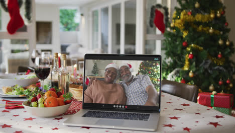 Glückliche-Afroamerikanische-Großeltern-Auf-Laptop-Liegend-Auf-Weihnachtstisch