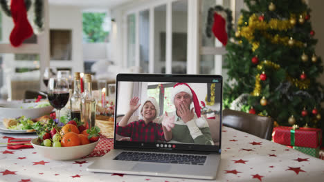 Happy-caucasian-father-and-son-on-laptop-lying-on-christmas-table