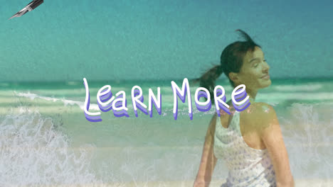 Animation-of-learn-more-over-happy-caucasian-woman-turning-out-on-beach