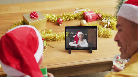 Kaukasischer-Vater-Und-Sohn-Mit-Weihnachtsmützen-Nutzen-Tablet-Für-Weihnachtsvideoanruf-Mit-Frau-Auf-Dem-Bildschirm