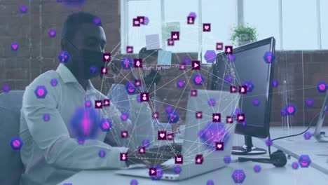 Animation-of-network-of-connections-with-icons-over-african-american-man-with-face-mask-using-laptop