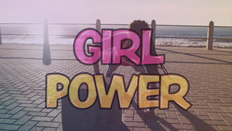 Animation-of-girl-power-text-over-biracial-woman-exercising-on-promenade