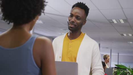 Happy-african-american-male-and-female-business-colleagues-talking-in-office