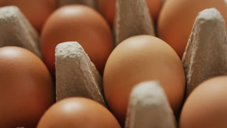 Video-of-close-up-of-brown-eggs-in-egg-carton-background