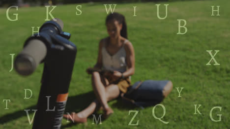 Animation-of-letters-over-biracial-woman-with-scooter-reading-in-park