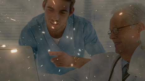 Animation-of-glowing-light-over-caucasian-male-doctors-using-computer