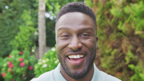 Portrait-of-smiling-african-american-man-looking-at-camera-in-garden