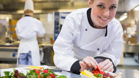 Smiling-caucasian-female-chef-wearing-apron-preparing-food-in-professional-kitchen