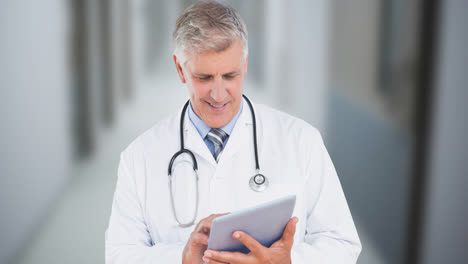 Animation-of-smiling-caucasian-male-doctor-with-tablet-over-corridor-in-hospital