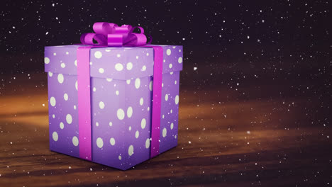 Animation-Von-Schnee,-Der-über-Ein-Lila-Weihnachtsgeschenk-Auf-Holzhintergrund-Fällt