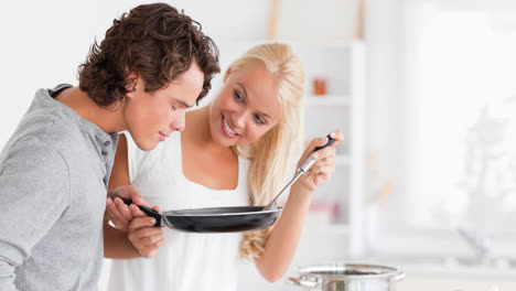 Smiling-caucasian-couple-preparing-food-together-in-kitchen-at-home