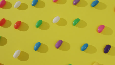 Video-Einer-Draufsicht-Auf-Reihen-Bunter-Süßigkeiten-Auf-Gelbem-Hintergrund