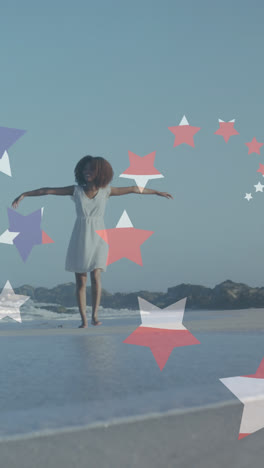 Animation-of-stars-and-american-flag-over-african-american-woman-raising-hands-at-beach