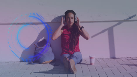 Animation-of-scope-scanning-over-biracial-woman-sitting-and-wearing-headphones
