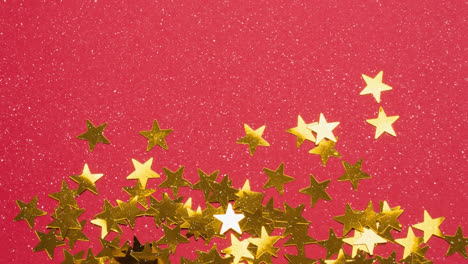 Animation-of-snow-falling-over-christmas-golden-stars-on-red-background