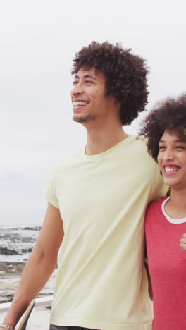 Biracial-couple-enjoys-a-day-at-the-beach,-with-copy-space