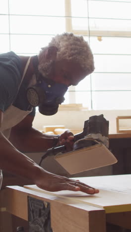 African-American-craftsman-sands-wood-in-a-workshop