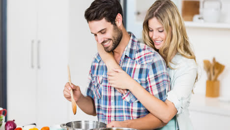 Smiling-caucasian-couple-preparing-food-together-in-kitchen-at-home