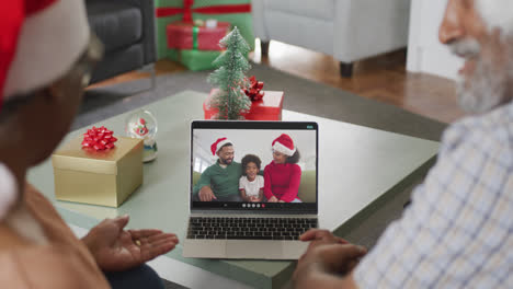 Happy-senior-african-american-couple-on-video-call-with-family-at-christmas-time