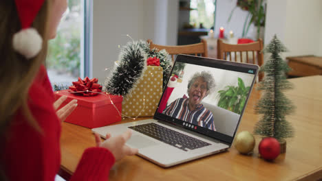 Caucasian-woman-on-laptop-video-call-with-happy-senior-woman-at-christmas-time
