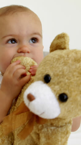 Cute-baby-girl-playing-with-teddy-bear-on-bed
