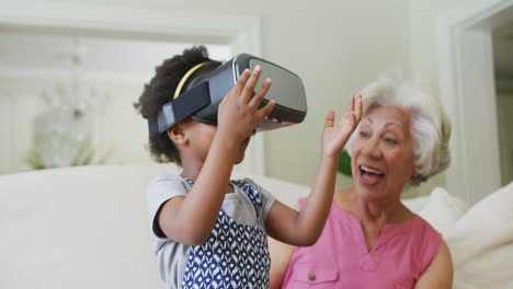 Glückliche-Afroamerikanische-Großmutter-Mit-Enkelin-Mit-VR-Headset-Im-Wohnzimmer