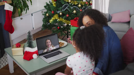 African-american-mother-and-daughter-having-a-videocall-on-laptop-at-home-during-christmas