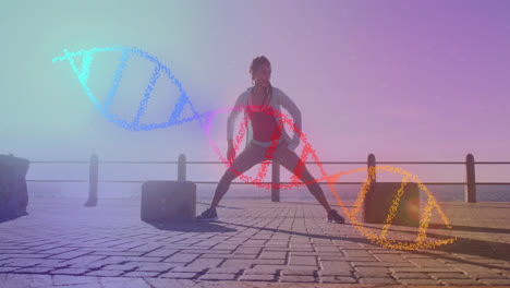 Animation-of-dna-strand-over-biracial-woman-stretching-on-promenade