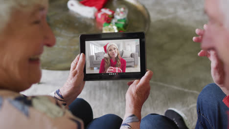 Senior-caucasian-couple-using-tablet-for-christmas-video-call-with-happy-woman-on-screen
