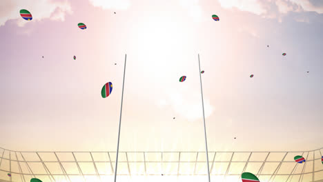 Animation-of-rugby-balls-coloured-with-flag-of-namibia-at-stadium