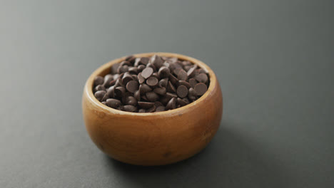 Video-of-wooden-bowl-of-chocolate-chip-over-grey-background