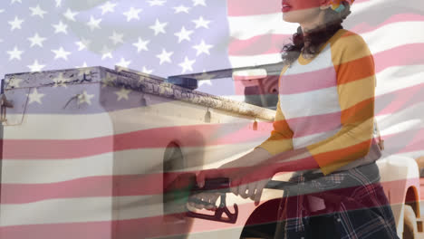 Animation-of-waving-usa-flag-over-woman-at-the-gas-station