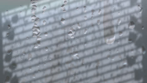 Animation-Von-Regentropfen-über-Fensterschatten-Auf-Grauem-Hintergrund