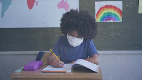 Animation-of-mathematical-equations-over-african-american-schoolboy-wearing-face-mask