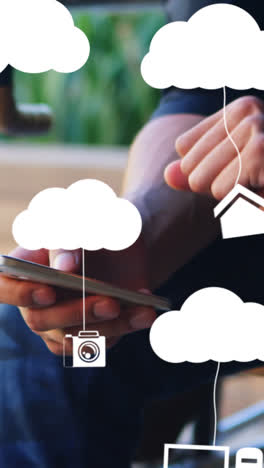 Animation-of-clouds-with-electronic-devices-over-caucasian-man-using-smartphone