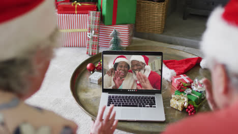 Älteres-Kaukasisches-Paar-Nutzt-Laptop-Für-Weihnachtsvideoanruf-Mit-Glücklichem-Paar-Auf-Dem-Bildschirm